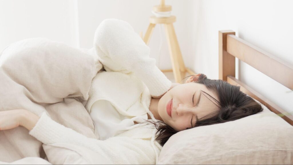 歯が痛くて眠れずにつらそうな女性