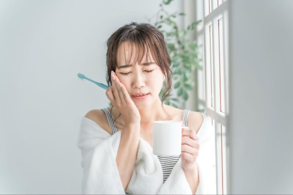 歯磨き中に親知らずが痛む女性