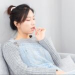 自分の頬に触れる女性
