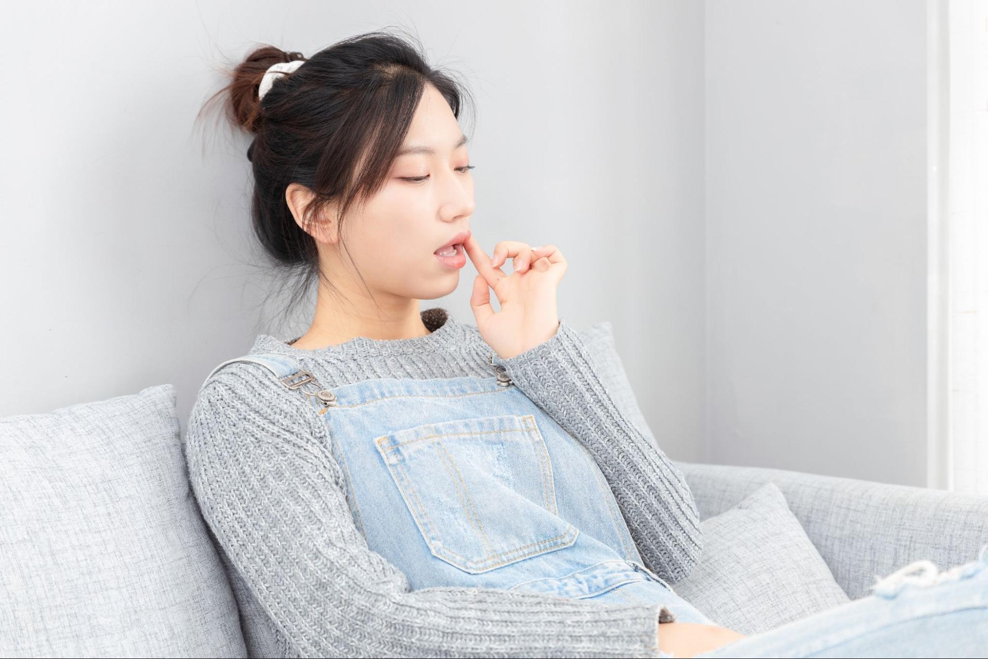 自分の頬に触れる女性