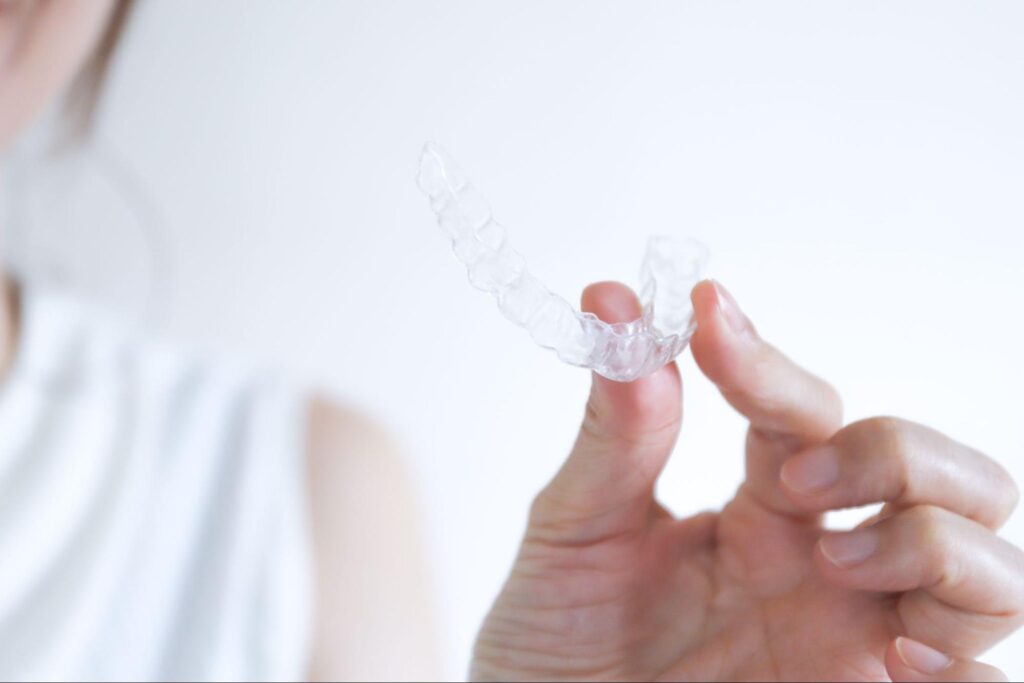 マウスピース矯正装置を持つ手元