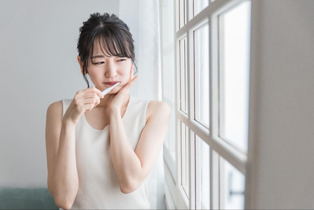 歯磨き中に親知らずが痛む女性