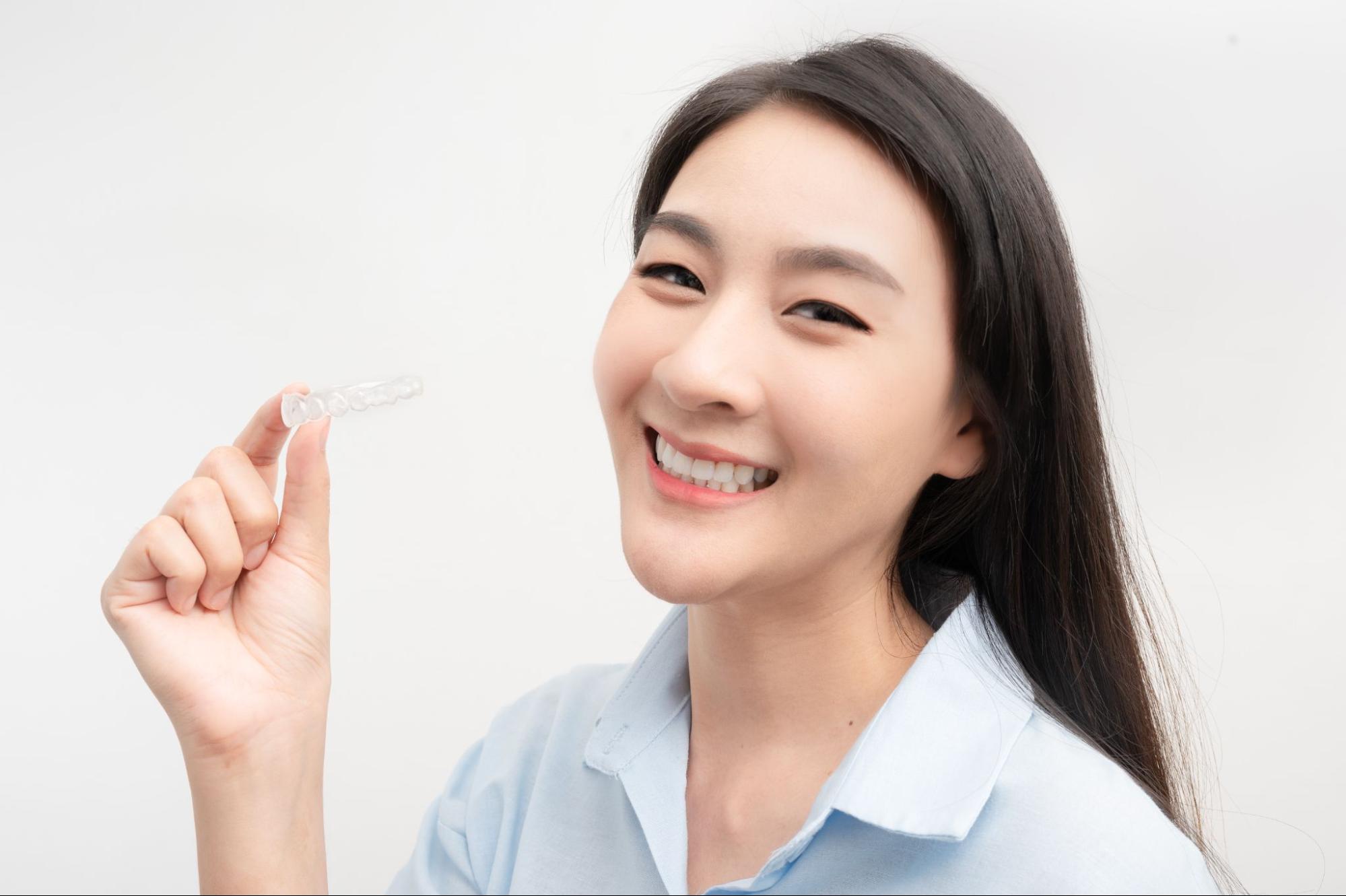 マウスピース矯正装置を持つ女性