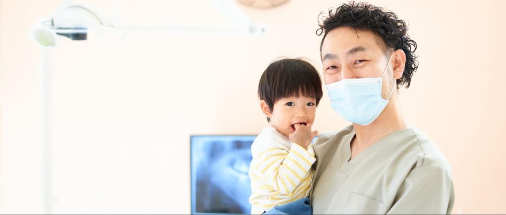歯科医師に抱っこされる子供