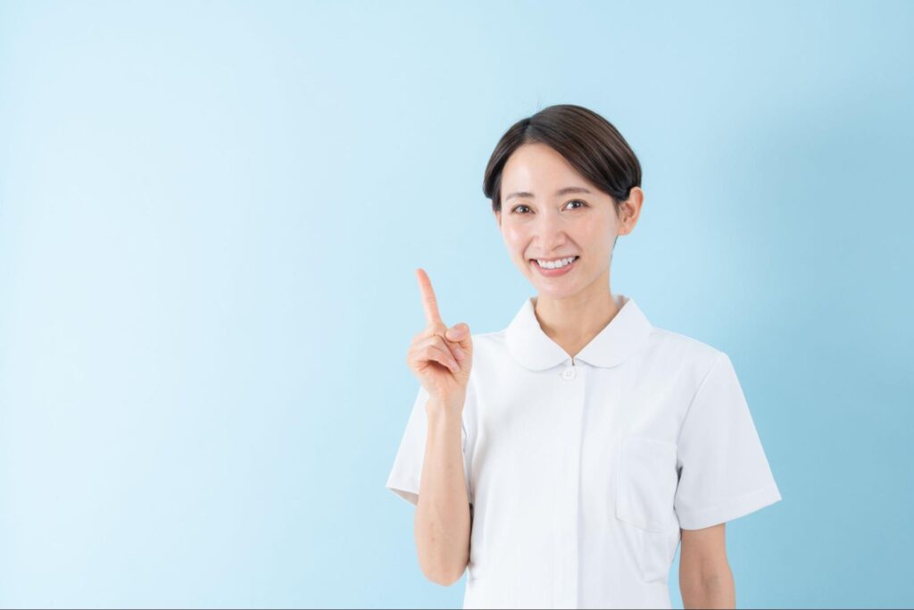 人差し指を立てる歯科医療従事者の女性
