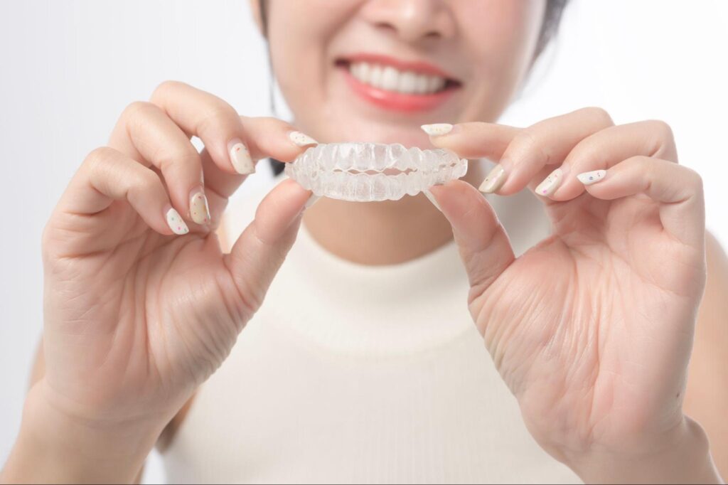 マウスピース矯正装置を持つ女性