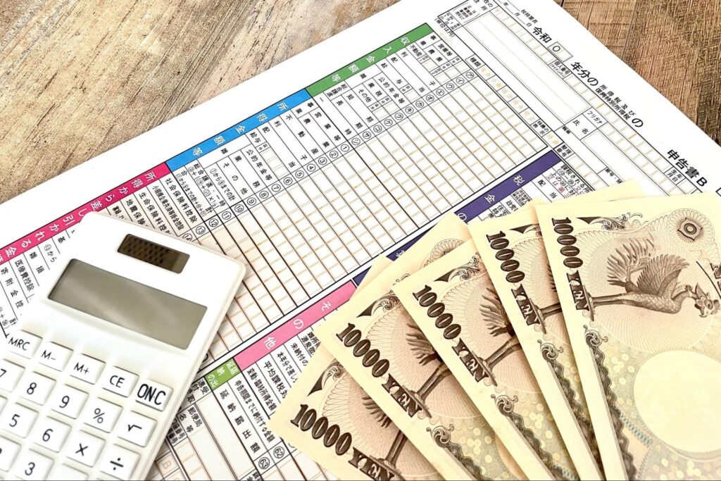 確定申告書と計算機と一万円札