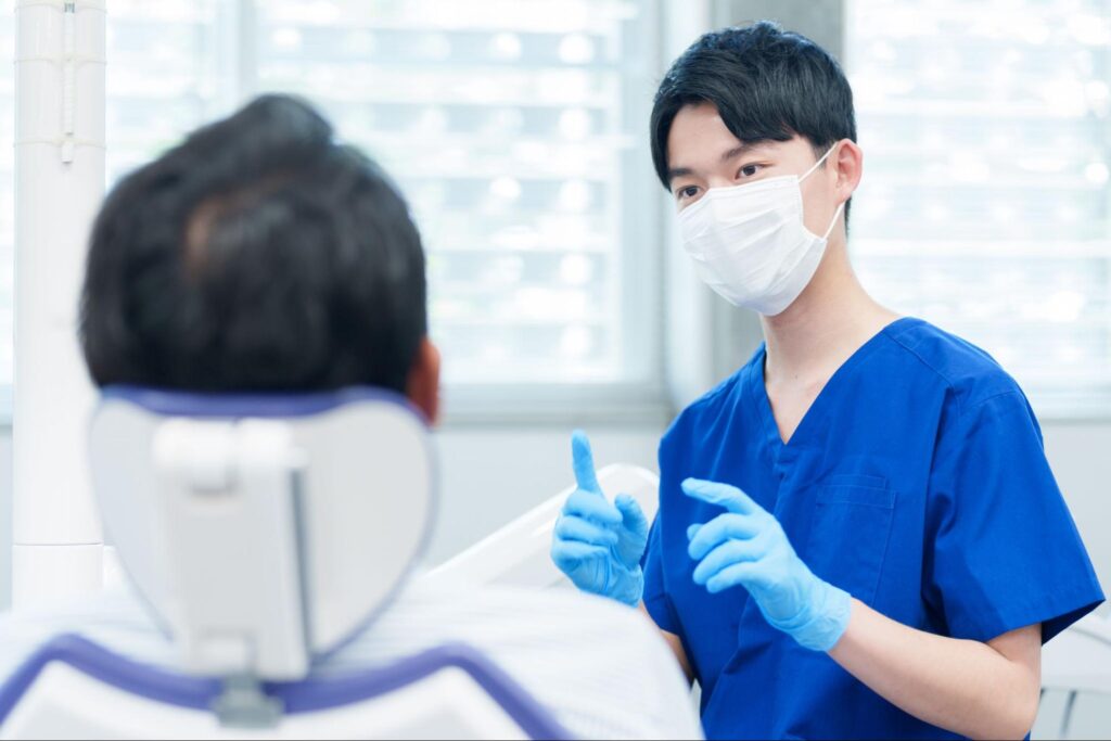 親知らずの抜歯を検討すべきケースについて説明している歯科医師
