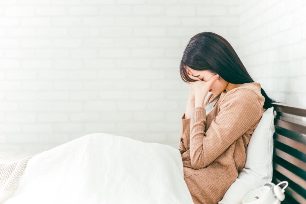 歯が痛くて眠れずにつらそうな女性