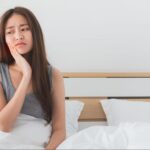 歯が痛そうにしている寝起きの女性