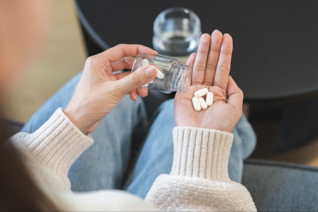 鎮痛剤を飲もうとしている人の手元